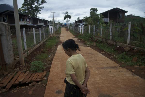 A Kachin woman walks in a Chinese-built village for residents forcibly relocated for the planned Myitsone hydroelectric dam. Photo: Jason Motlagh. Burma, 2012.